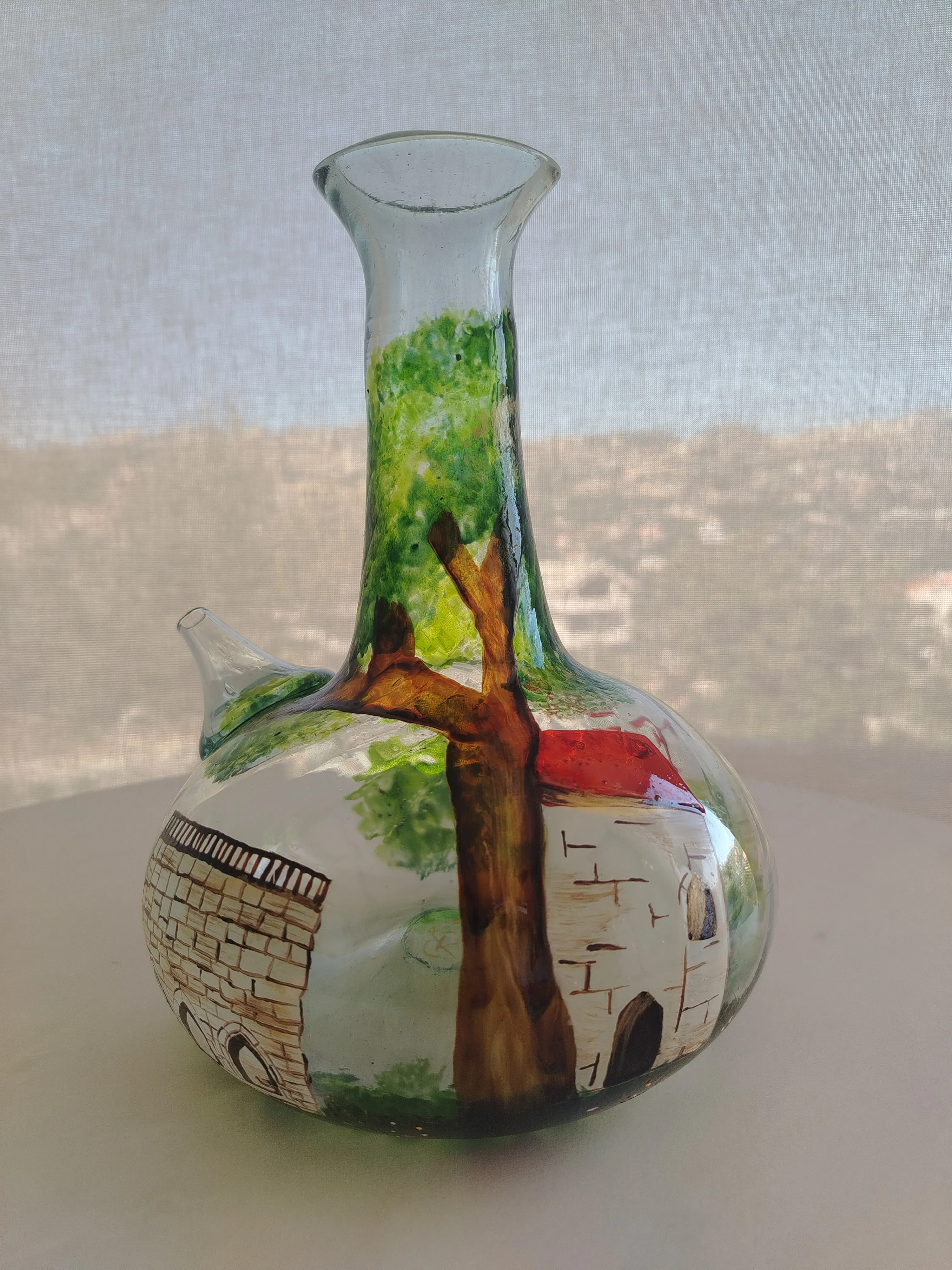 Detailed view of a Lebanese village hand-painted onto glass, with terracotta rooftops and earth tones